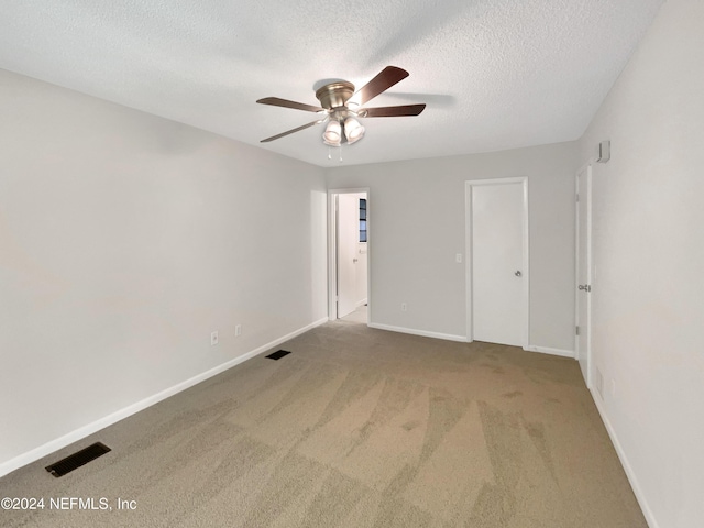 spare room with ceiling fan, carpet floors, and a textured ceiling