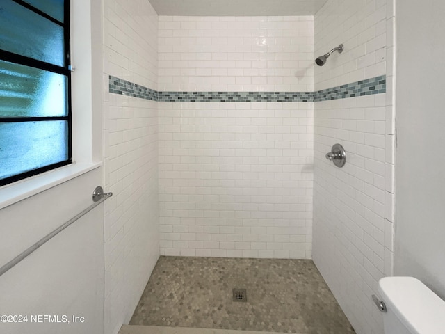 bathroom with tiled shower and toilet