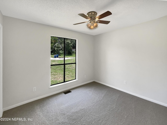 carpeted spare room featuring ceiling fan and a textured ceiling