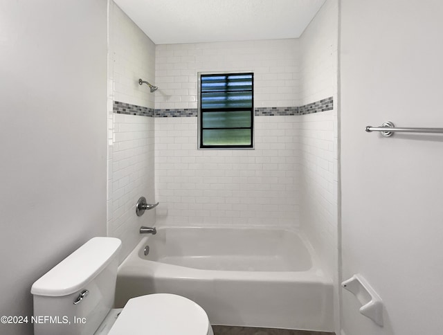 bathroom featuring tiled shower / bath and toilet