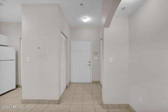 hall with electric panel and light tile patterned floors