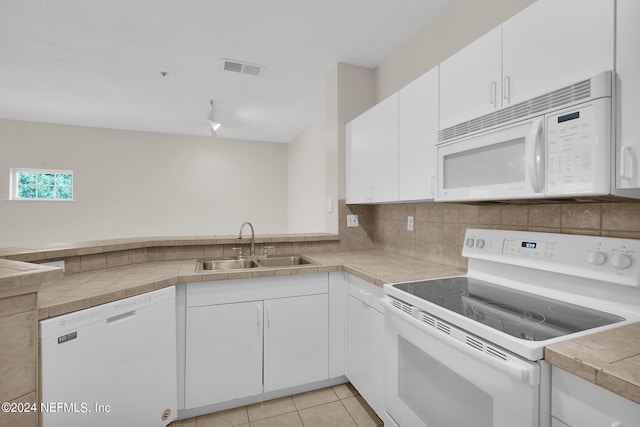 kitchen with white cabinetry, light tile patterned flooring, tasteful backsplash, white appliances, and sink