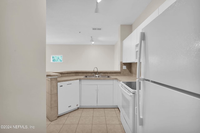 kitchen with light tile patterned flooring, sink, white appliances, and white cabinetry