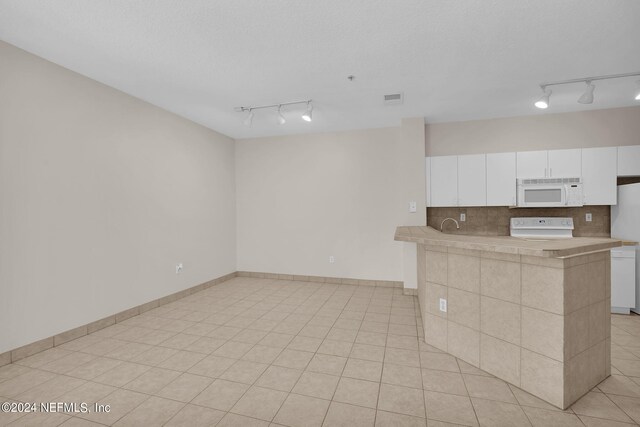 kitchen featuring white cabinetry, tasteful backsplash, white appliances, and rail lighting