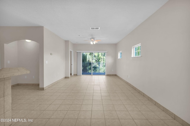 tiled empty room with ceiling fan