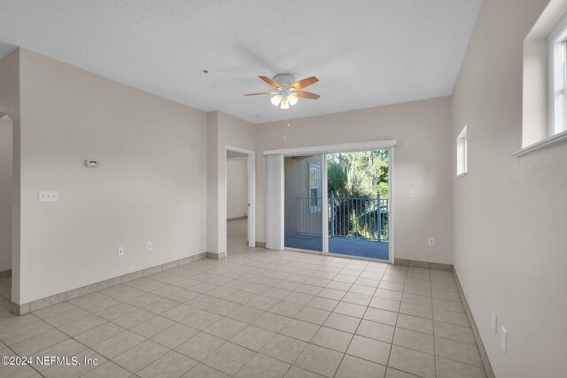 tiled spare room featuring ceiling fan