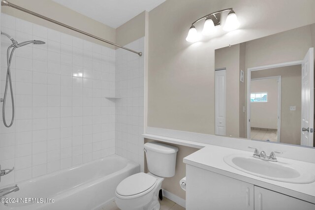 full bathroom with toilet, tile patterned floors, tiled shower / bath combo, and vanity