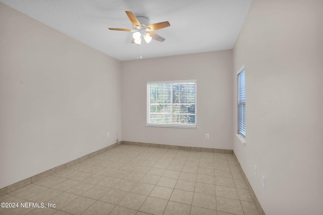 empty room with light tile patterned flooring and ceiling fan