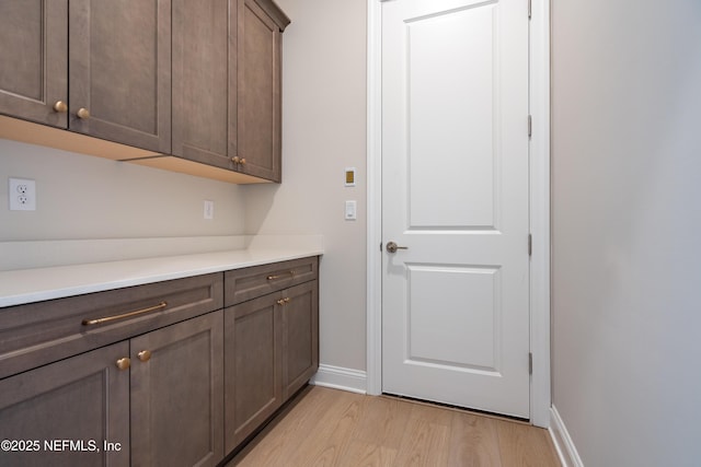 laundry area with light wood-type flooring