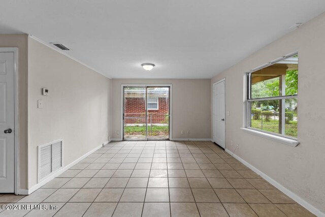 tiled empty room featuring a healthy amount of sunlight