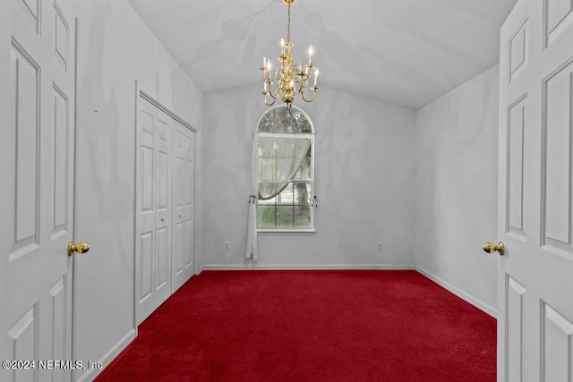 carpeted spare room with a notable chandelier