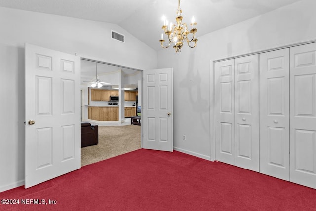 unfurnished bedroom featuring lofted ceiling, a notable chandelier, a closet, and carpet