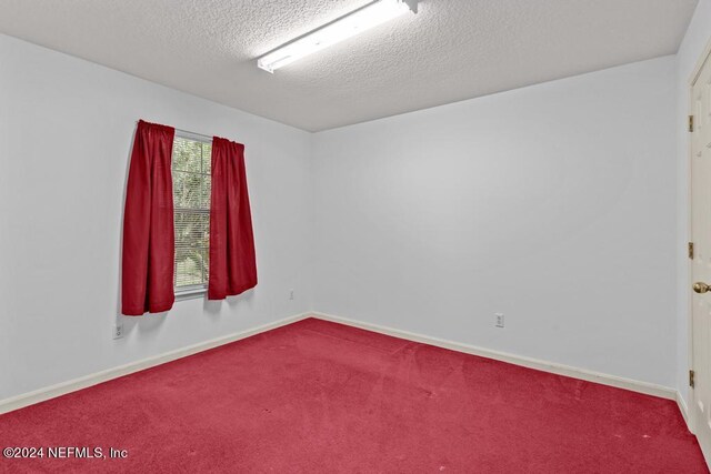 spare room with carpet flooring and a textured ceiling