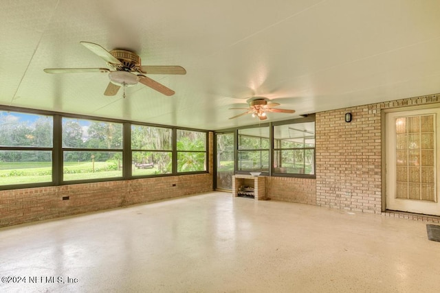 unfurnished sunroom with ceiling fan and plenty of natural light