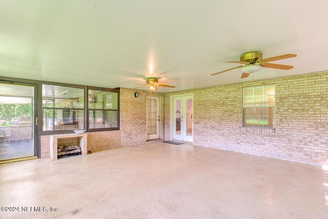 unfurnished living room with brick wall and ceiling fan