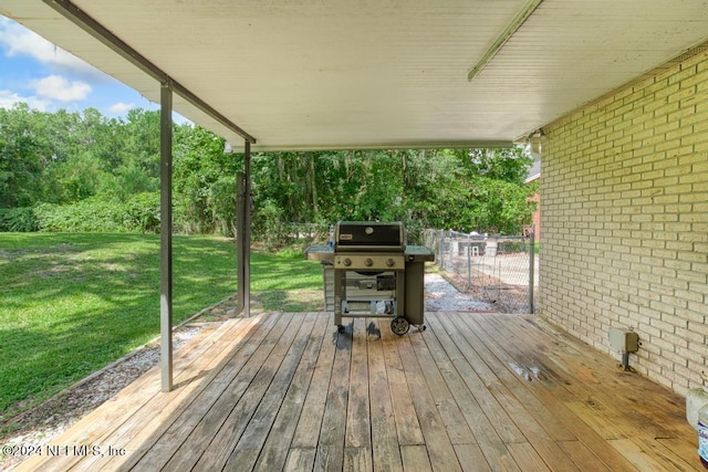 wooden terrace with area for grilling and a lawn