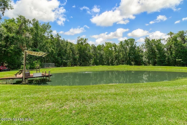 view of community with a water view and a lawn