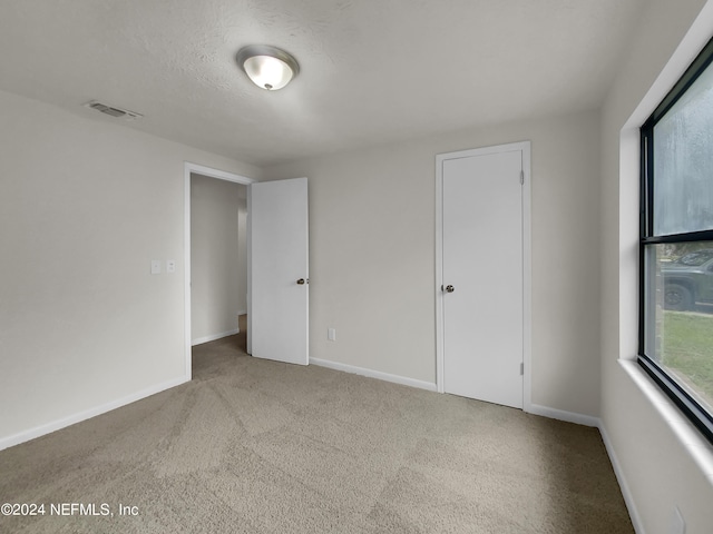 carpeted empty room featuring a textured ceiling