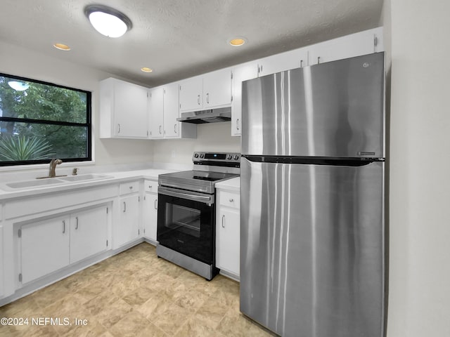 kitchen with a textured ceiling, appliances with stainless steel finishes, white cabinetry, and sink