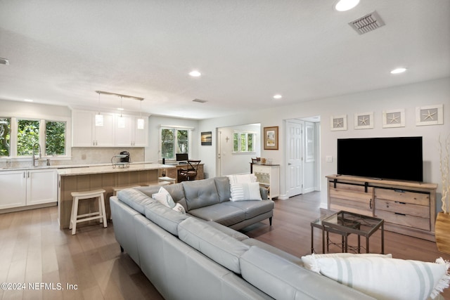 living room featuring sink and light hardwood / wood-style floors