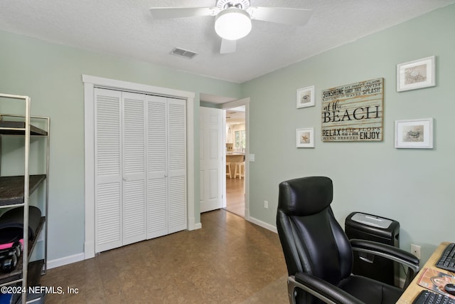 office space featuring ceiling fan and a textured ceiling