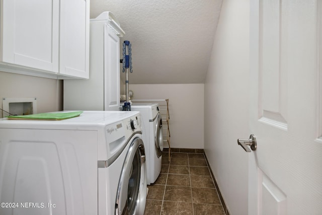 washroom featuring cabinets, a textured ceiling, and washing machine and dryer