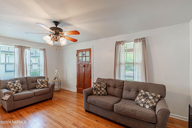 living room featuring a wealth of natural light, ceiling fan, and light wood-type flooring