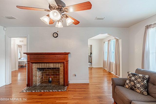 living room featuring hardwood / wood-style flooring, a fireplace, a wealth of natural light, and ceiling fan