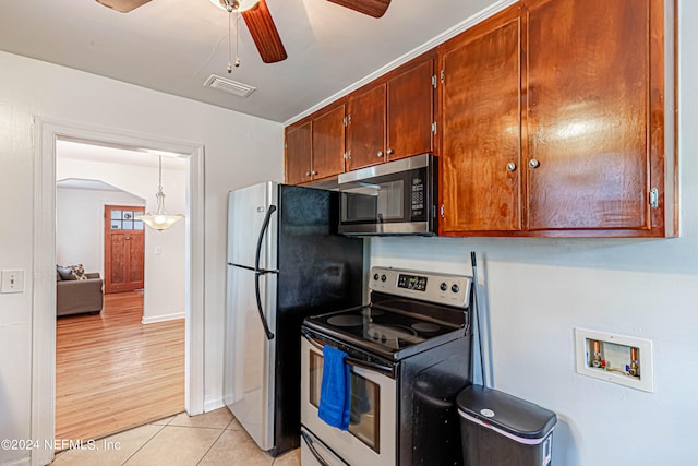 kitchen with decorative light fixtures, light hardwood / wood-style flooring, appliances with stainless steel finishes, and ceiling fan