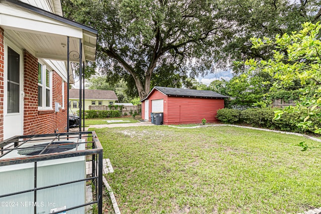 view of yard with a garage and an outbuilding