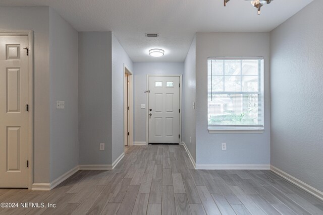 foyer featuring a textured ceiling and light hardwood / wood-style flooring