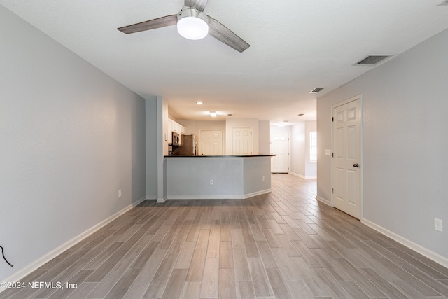 unfurnished living room featuring light hardwood / wood-style flooring and ceiling fan