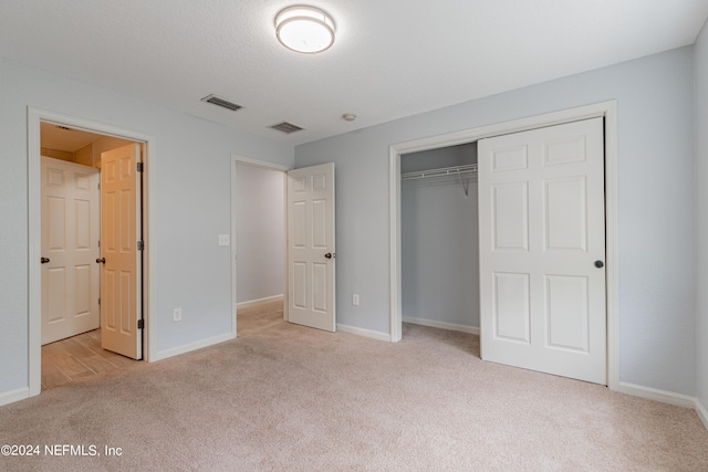 unfurnished bedroom with a closet and light carpet