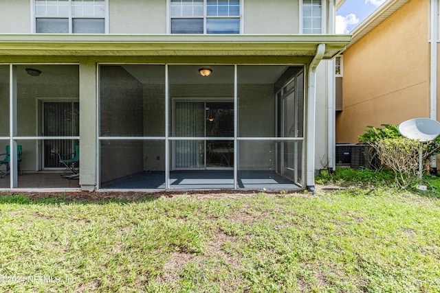 entrance to property with central AC and a lawn