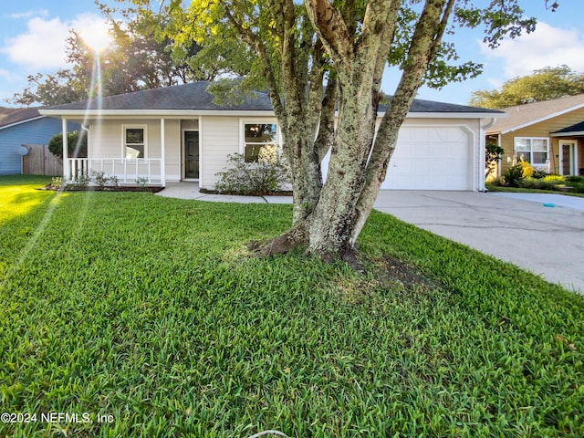 single story home featuring a garage, a front yard, and a porch