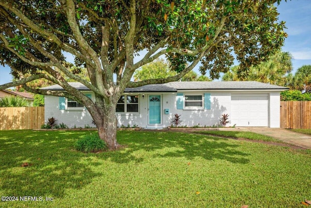 ranch-style home featuring a garage and a front lawn