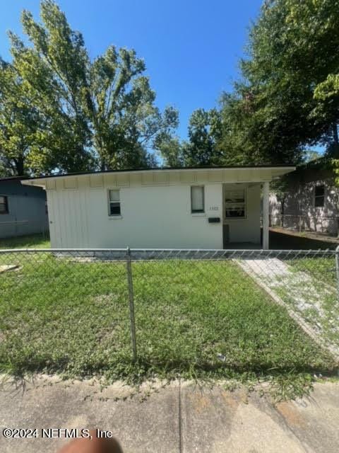 ranch-style house with fence and a front lawn