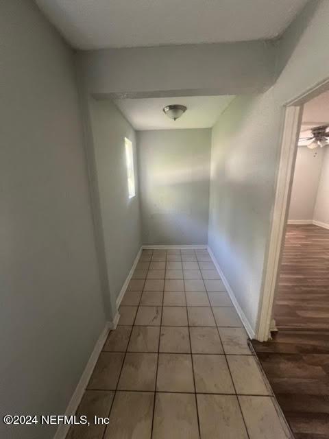 hallway featuring baseboards and light tile patterned floors