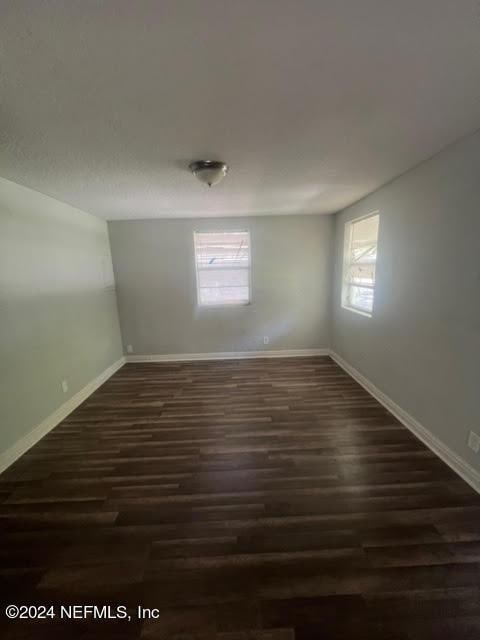 unfurnished room featuring dark wood finished floors and baseboards