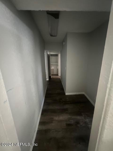 corridor with wood finished floors and baseboards