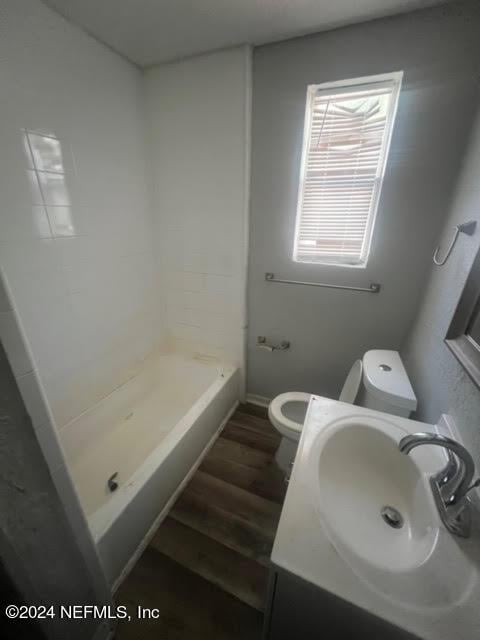 full bathroom with vanity, wood finished floors, walk in shower, and toilet