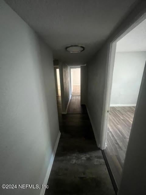 hallway with baseboards and dark wood finished floors