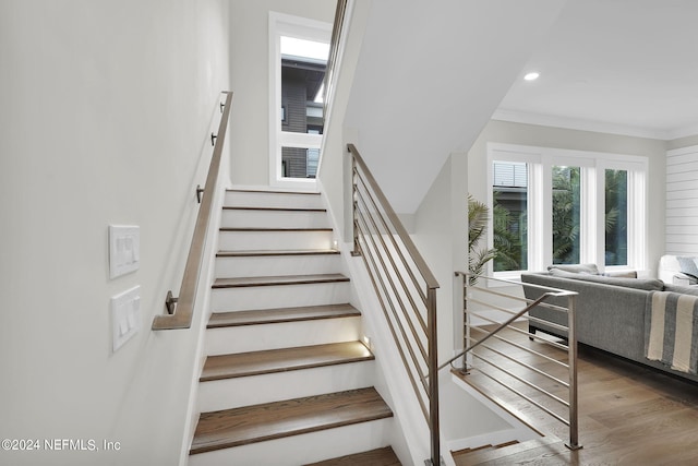 stairs featuring crown molding and hardwood / wood-style flooring