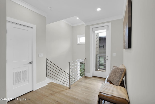 foyer entrance featuring crown molding and light hardwood / wood-style floors