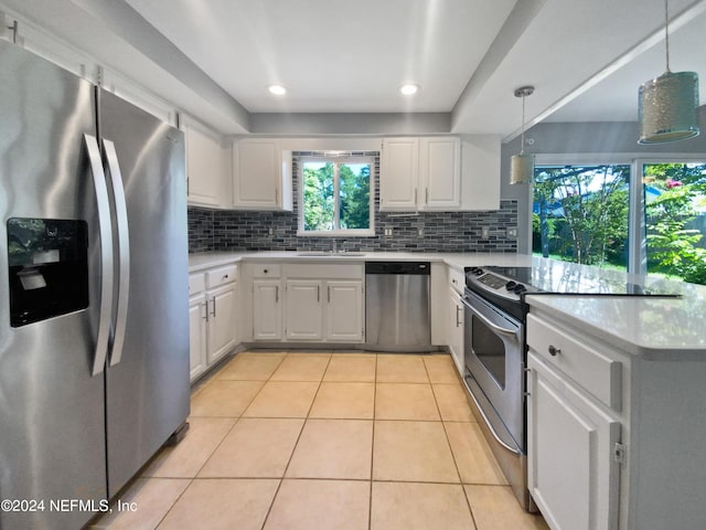 kitchen with white cabinetry, appliances with stainless steel finishes, and hanging light fixtures