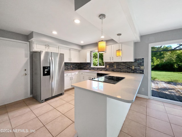 kitchen featuring white cabinets, kitchen peninsula, hanging light fixtures, and stainless steel fridge