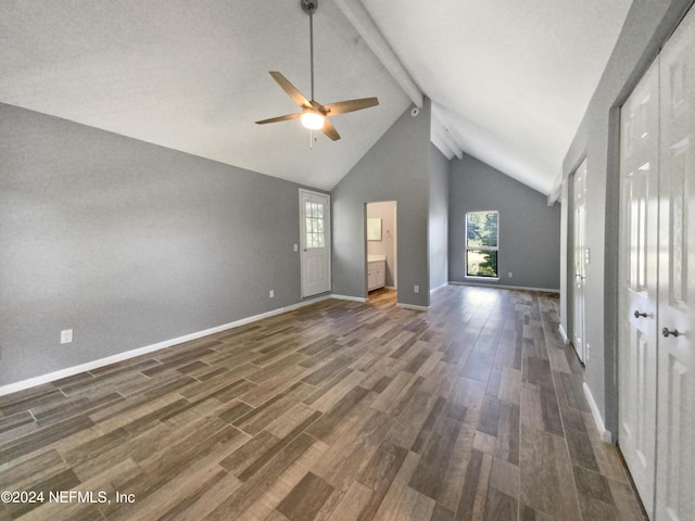 unfurnished living room featuring dark hardwood / wood-style flooring, beamed ceiling, and a healthy amount of sunlight