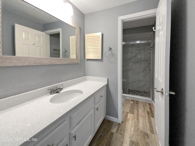 bathroom with vanity, hardwood / wood-style floors, and a shower with shower door