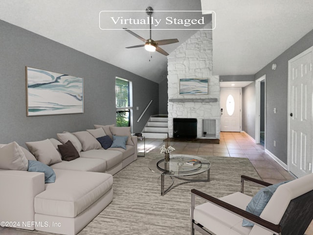 living room featuring light tile patterned flooring, vaulted ceiling, ceiling fan, and a fireplace