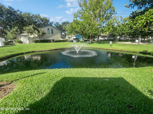 surrounding community with a water view and a yard